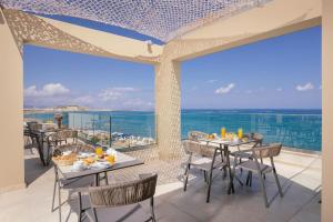 een restaurant met uitzicht op de oceaan bij Batis Beach Hotel in Rethimnon