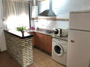 a kitchen with a washing machine and a microwave at Conil Colorado 1 rústico y económico in Conil de la Frontera