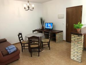 a living room with a table with a laptop on it at Conil Colorado 1 rústico y económico in Conil de la Frontera
