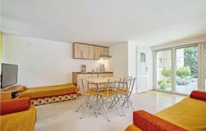 a kitchen and living room with a table and chairs at Awesome Apartment In Grzybowo With Kitchenette in Grzybowo