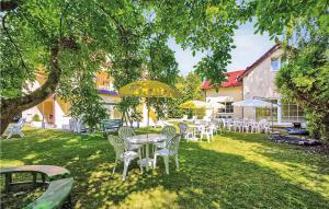 a group of tables and chairs with umbrellas in a yard at Awesome Apartment In Grzybowo With Kitchenette in Grzybowo