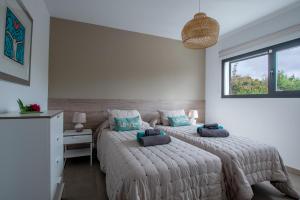 ラ・オリーバにあるWind Wave 28B - Heated & Shared poolのベッド2台と机と窓のある寝室