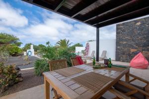ラ・オリーバにあるWind Wave 28B - Heated & Shared poolのパティオにある木製のテーブルと椅子