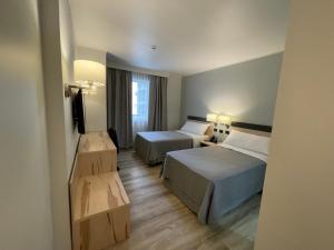 um quarto de hotel com duas camas e uma televisão em Diego de Almagro Providencia Express em Santiago