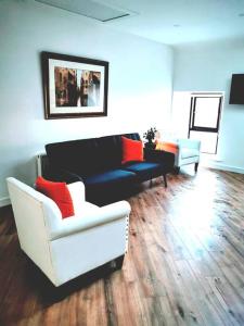 ein Wohnzimmer mit 2 Stühlen und einem Sofa in der Unterkunft Elmwood House Luxury Seaview Accommodation in Donegal
