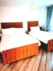 dos camas sentadas una al lado de la otra en un dormitorio en Elmwood House Luxury Seaview Accommodation, en Donegal