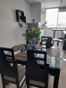 a dining room with a glass table and chairs at Apartamento y Piscina a 3' del Parque del Cafe in Montenegro