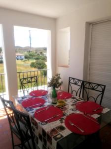 een eetkamer met een tafel met rode borden bij 3 bedroom apartment with pool & parking, close to sea and golf in Manilva