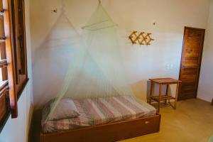ein Schlafzimmer mit einem Bett mit einem Netz darauf in der Unterkunft Casa ampla c redes de descanso, Praia de Macapa PI in Luis Correia