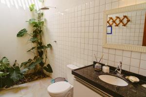 ein Badezimmer mit Waschbecken, Toilette und Spiegel in der Unterkunft Casa ampla c redes de descanso, Praia de Macapa PI in Luis Correia