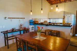 eine Küche mit einem Holztisch mit einer Vase mit Blumen darauf in der Unterkunft Casa ampla c redes de descanso, Praia de Macapa PI in Luis Correia + 17 Fotos