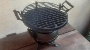 a charcoal grill sitting on top of a wooden table at BIKE apartments 3 in Hodruša