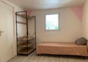 um quarto com uma cama, uma prateleira e uma janela em Ravissant logement avec jacuzzi em Lançon-Provence