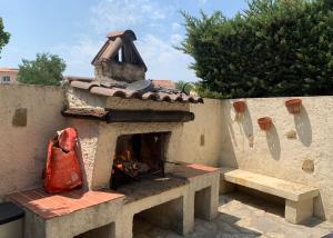 uma lareira de pedra com um saco vermelho na parede em Ravissant logement avec jacuzzi em Lançon-Provence