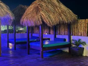 a resort with blue chairs and straw umbrellas at Casa Velero Puerto Morelos in Puerto Morelos