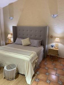 a bedroom with a large bed and two night stands at Villa Quinta Lomas casa completa con aéreas verdes in León