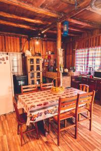 eine Küche mit einem Tisch mit Stühlen und einem Kühlschrank in der Unterkunft Chalé incrível c/ piscina, Águas Mornas - SC in Aguas Mornas