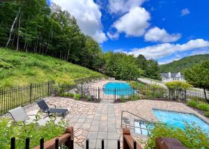 a backyard with a pool and a fence at Le Lightroom by Gestion ELITE in Mont-Tremblant