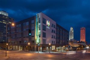 奥马哈EVEN Hotel Omaha Downtown - Old Market by IHG的城市的建筑,夜晚有绿灯