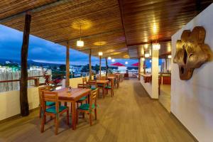 un restaurant avec des tables et des chaises sur un balcon dans l'établissement Plaza Luna Suites, à Puerto Ayora