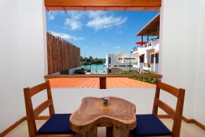 a table and two chairs on a balcony with a window at Plaza Luna Suites in Puerto Ayora