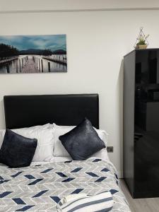 a bedroom with a bed with pillows and a painting on the wall at BV Lush Studio At Queensgate Huddersfield Town Centre in Huddersfield