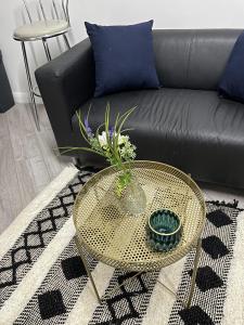 a coffee table with a vase of flowers on it at BV Lush Studio At Queensgate Huddersfield Town Centre in Huddersfield