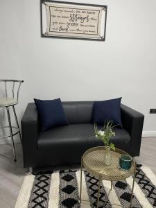 a living room with a black couch and a table at BV Lush Studio At Queensgate Huddersfield Town Centre in Huddersfield
