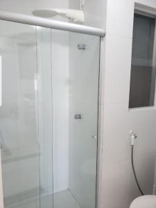 a shower with a glass door in a bathroom at Village Duplex, Vilas do Atlântico in Lauro de Freitas