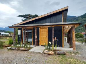 a small house with a large wooden door at Cabanas Senderos Puyuhuapi in Puerto Puyuhuapi