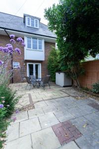 a patio with two chairs and a table in front of a house at Tankerton Town House, 1 parking space, 150m beach in Whitstable