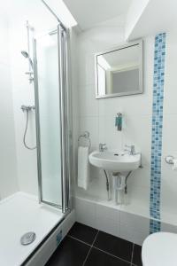 uma casa de banho branca com um lavatório e um chuveiro em Tankerton Town House, 1 parking space, 150m beach em Whitstable