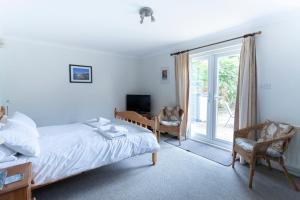 um quarto com uma cama e uma porta de vidro deslizante em Tankerton Town House, 1 parking space, 150m beach em Whitstable