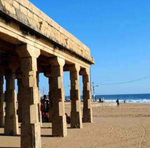 a building on a beach with the ocean in the background at Hotel Sunday - Townhouse Club Airport Trivandrum in Trivandrum