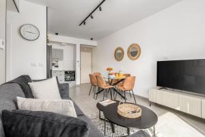a living room with a couch and a tv and a table at 2BDR W parking shirat haneviim - Mamilla Area sea-u jerusalem in Jerusalem