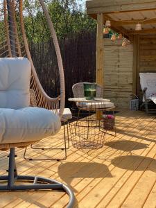 a patio with a chair and a table on a deck at Cabane au style scandinave et son bain nordique in Bouillon +23 photos
