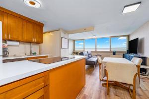 eine Küche und ein Wohnzimmer mit einem Tisch und einem Sofa in der Unterkunft Island Colony 3821 in Honolulu