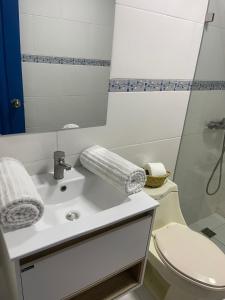 a bathroom with a sink and a toilet and a mirror at Nuovo Hotel Playa Catalina in La Romana