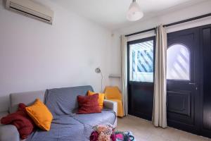 sala de estar con sofá azul y ventana en Romantico Open Space a 3min dalla spiaggia - HomeUnity, en Rímini