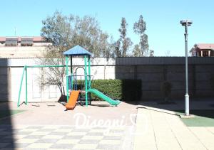 un parque infantil con un tobogán frente a un edificio en Departamento Av. Los Carrera Copiapó Disegni 07, en Copiapó
