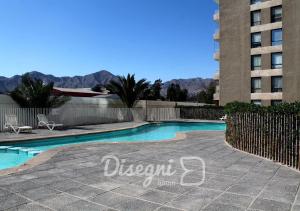 a swimming pool in front of a tall building at Departamento Av. Los Carrera Copiapó Disegni 07 in Copiapó