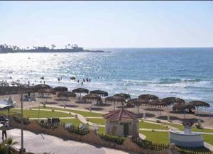 a beach with umbrellas and people on the beach at 2bed rooms 95m, Garden&sea view, first floor, Family only دور اول بمدخل مستقل in Alexandria