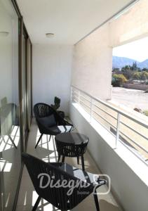 - un balcon avec deux chaises et une table dans l'établissement Departamento Av. Los Carrera Copiapó Disegni 07, à Copiapó