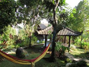 a hammock in a garden with a gazebo at D'kailash Retreat in Singaraja