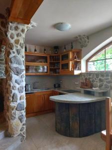 a kitchen with a stone wall and a stone island at Zerko Holiday Home - Vineyard Chalet With Sauna and Jacuzzi FREE in Mirna