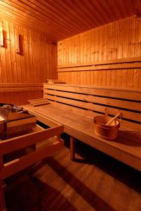 - un sauna en bois avec un bol sur un banc dans l'établissement Horský Hotel Kohútka, à Nový Hrozenkov