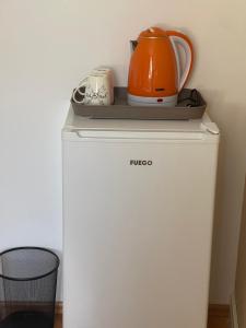 an orange tea kettle on top of a refrigerator at Guesthouse 12a in Pristina