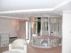 a living room with white chairs and a table at Chateau Royale Inn in Lake Geneva