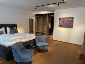 ein Schlafzimmer mit einem Bett, zwei Stühlen und einem Gemälde in der Unterkunft City Apartment Downtown Vienna in Wien