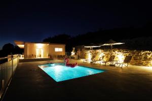 een zwembad in een tuin 's nachts bij Villa Tzekos in Kendrokhórion